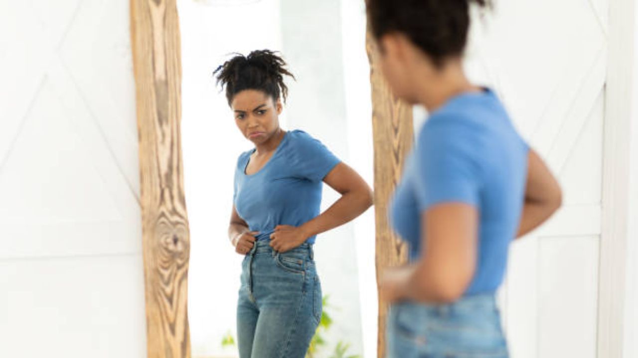 fotos de barriga com diástase mulher se olhando no espelho incomodada com sua barriga com diástase